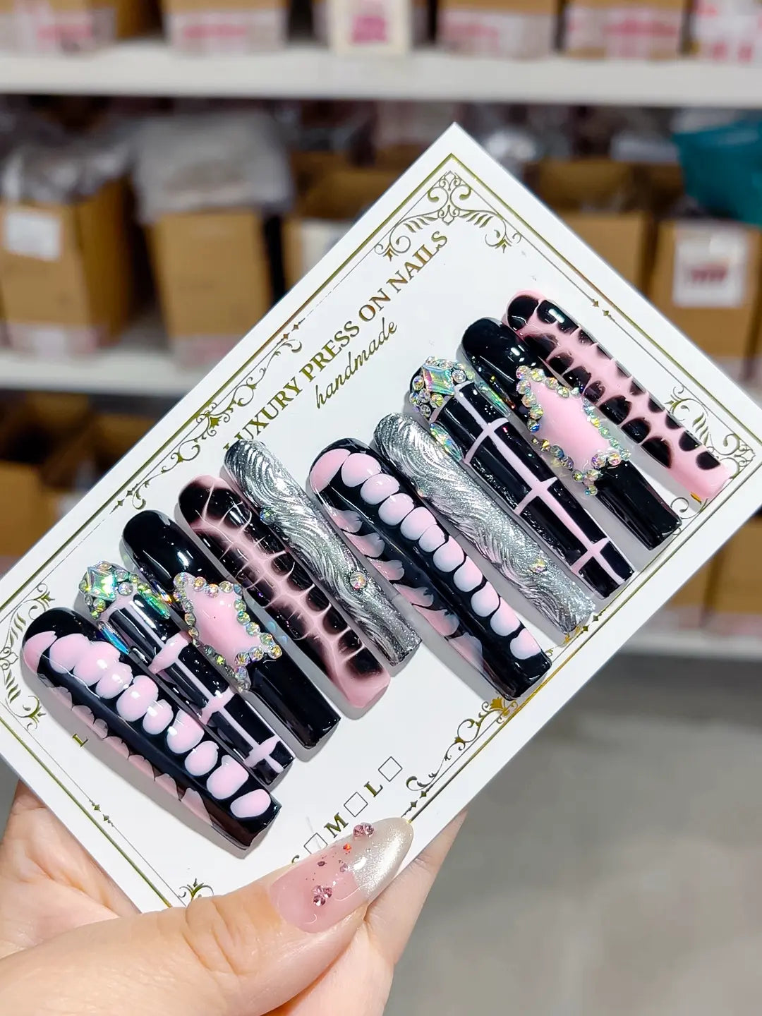 handmade press on nails set in long square black and pink with chrome accents and 3D rhinestone frame centerpiece