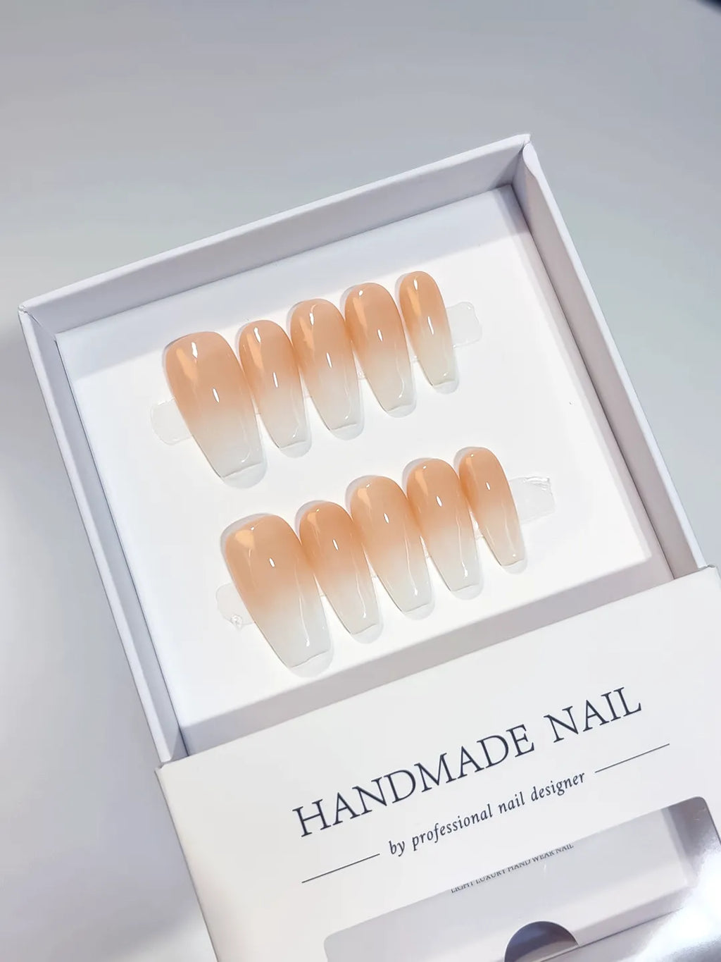 Set of handmade medium coffin press-on nails with an elegant peach and white ombre design. The gradient transitions smoothly, offering a chic and sophisticated look suitable for any occasion. Perfect for a natural yet stylish manicure.