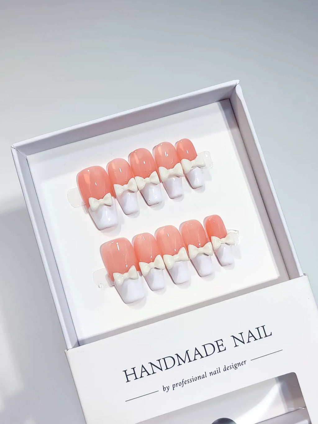 Pink White French tip Bow press on nails angled view