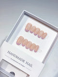 Short oval press-on nails feature a sheer nude base with soft lavender purple French tips, showcasing a glossy finish. The elegant set is displayed neatly in a clean white product box.