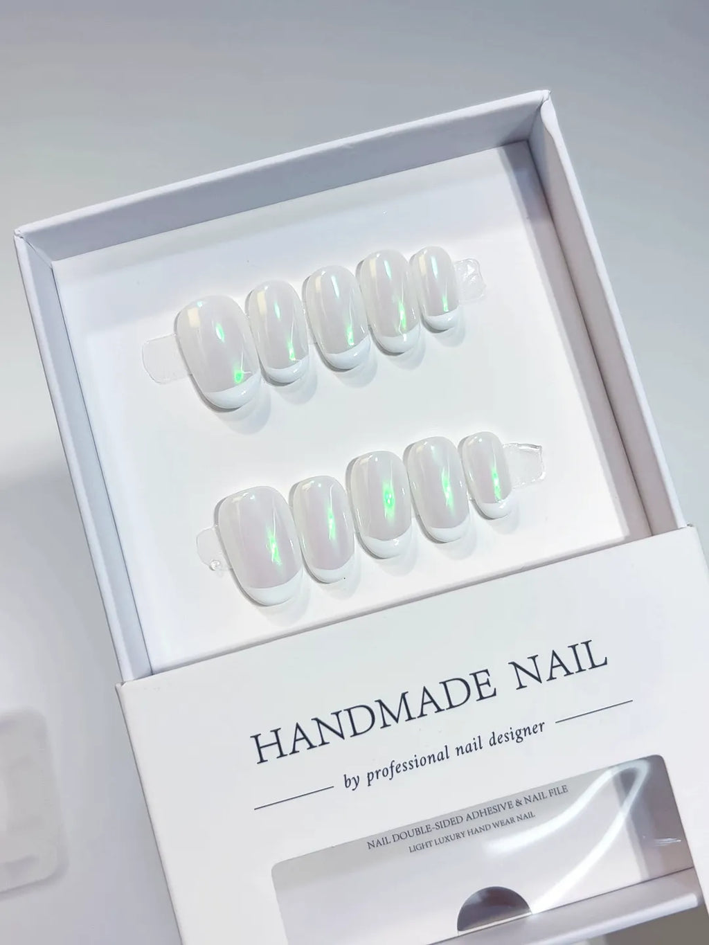 Handmade press on nails short oval white with green aurora shine, angled display