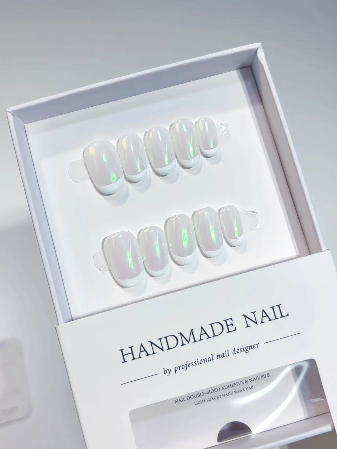 Handmade press on nails short oval white with green aurora shine, angled display
