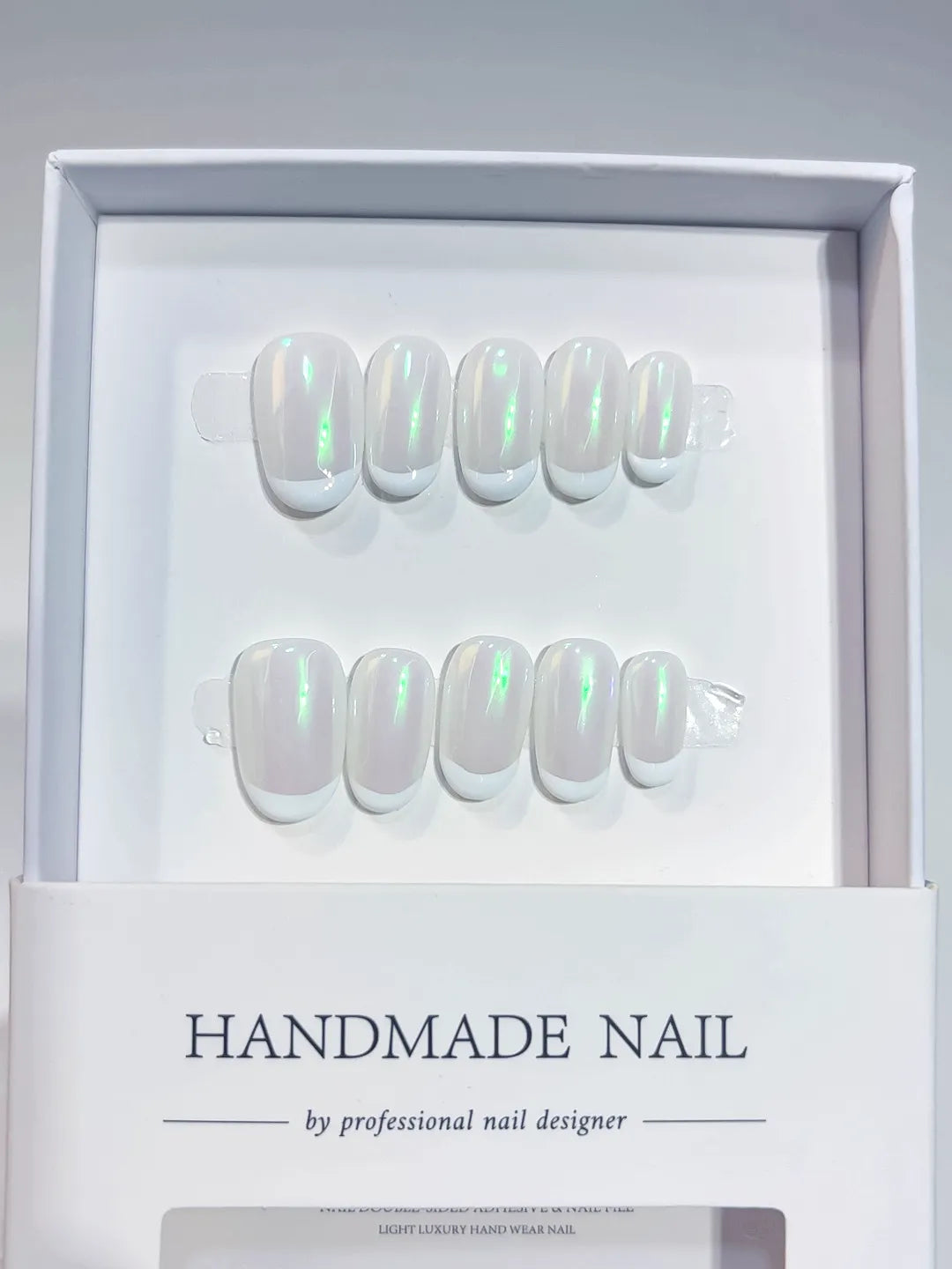 Handmade press on nails short oval white with green aurora shine, angled display