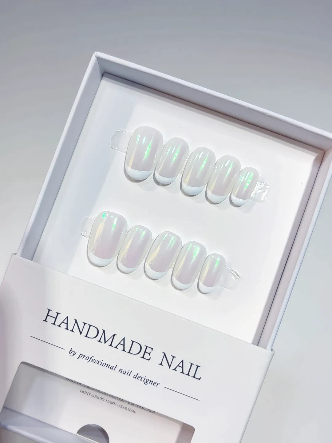 Handmade press on nails short oval white with green aurora shine, angled display