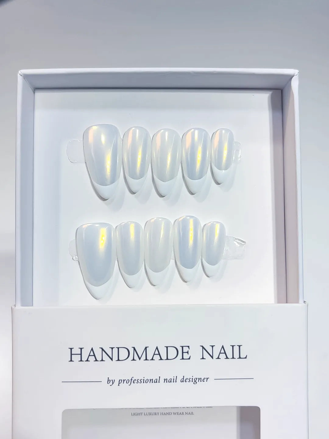 handmade press on nails medium almond white french with yellow aurora shine, angled view