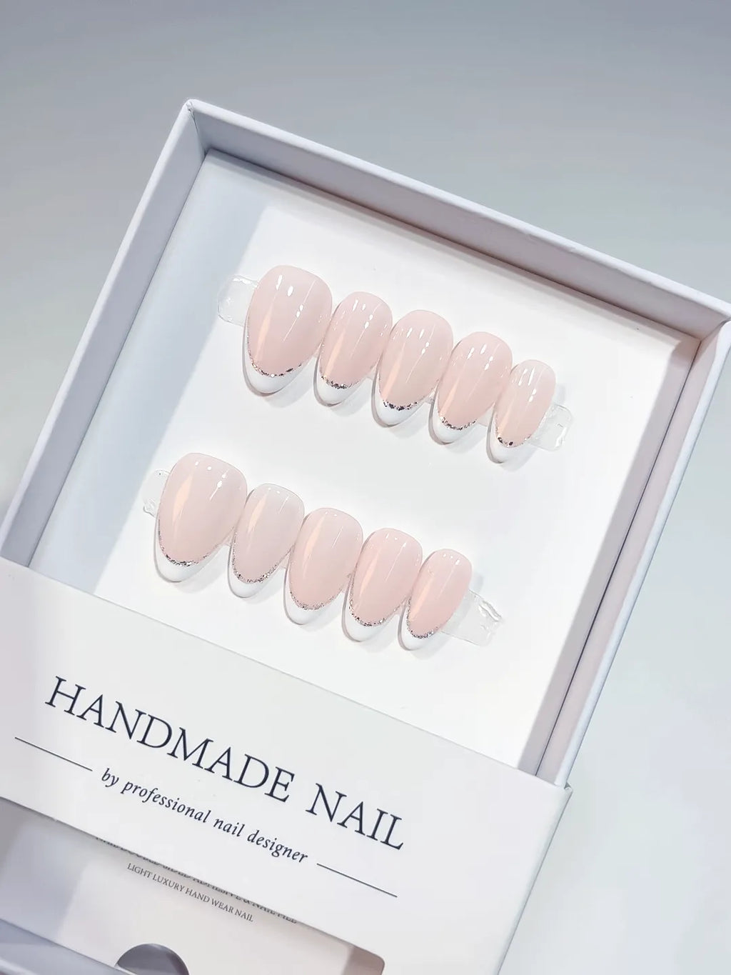handmade press on nails short almond pink french glitter detail, close-up view