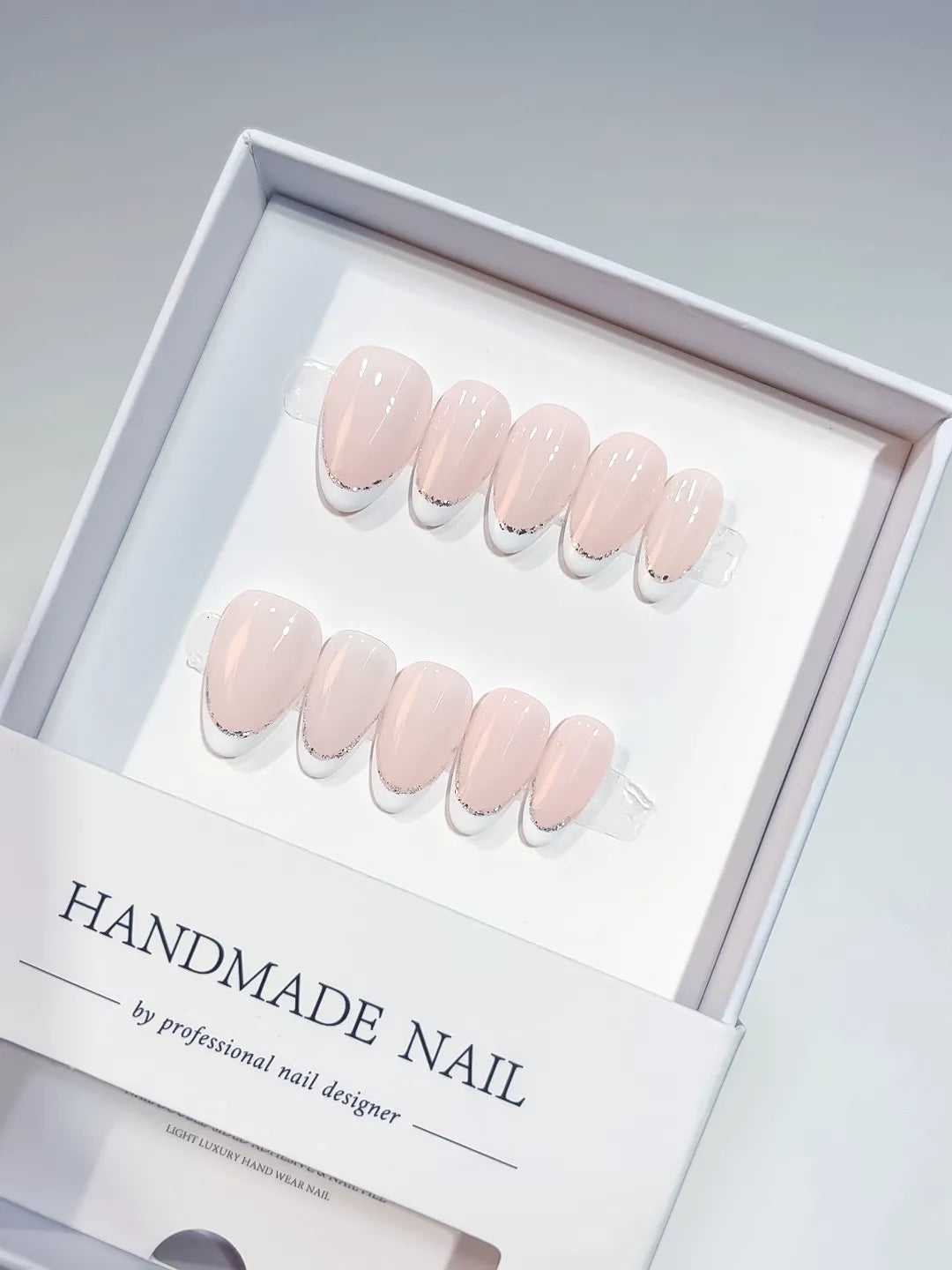 handmade press on nails short almond pink french glitter detail, close-up view