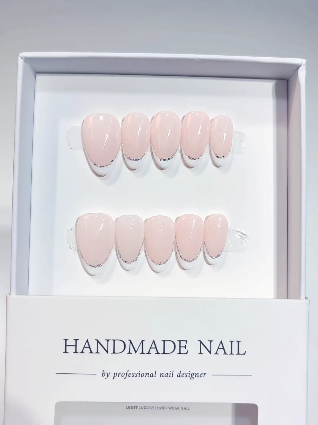 handmade press on nails short almond pink french glitter detail, close-up view