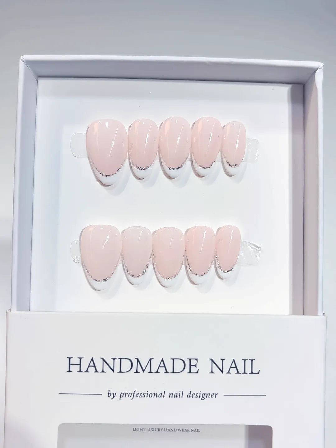 handmade press on nails short almond pink french glitter detail, close-up view