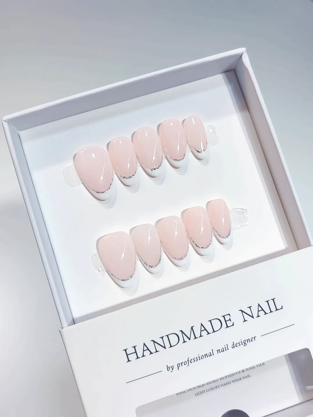 handmade press on nails short almond pink french glitter detail, close-up view