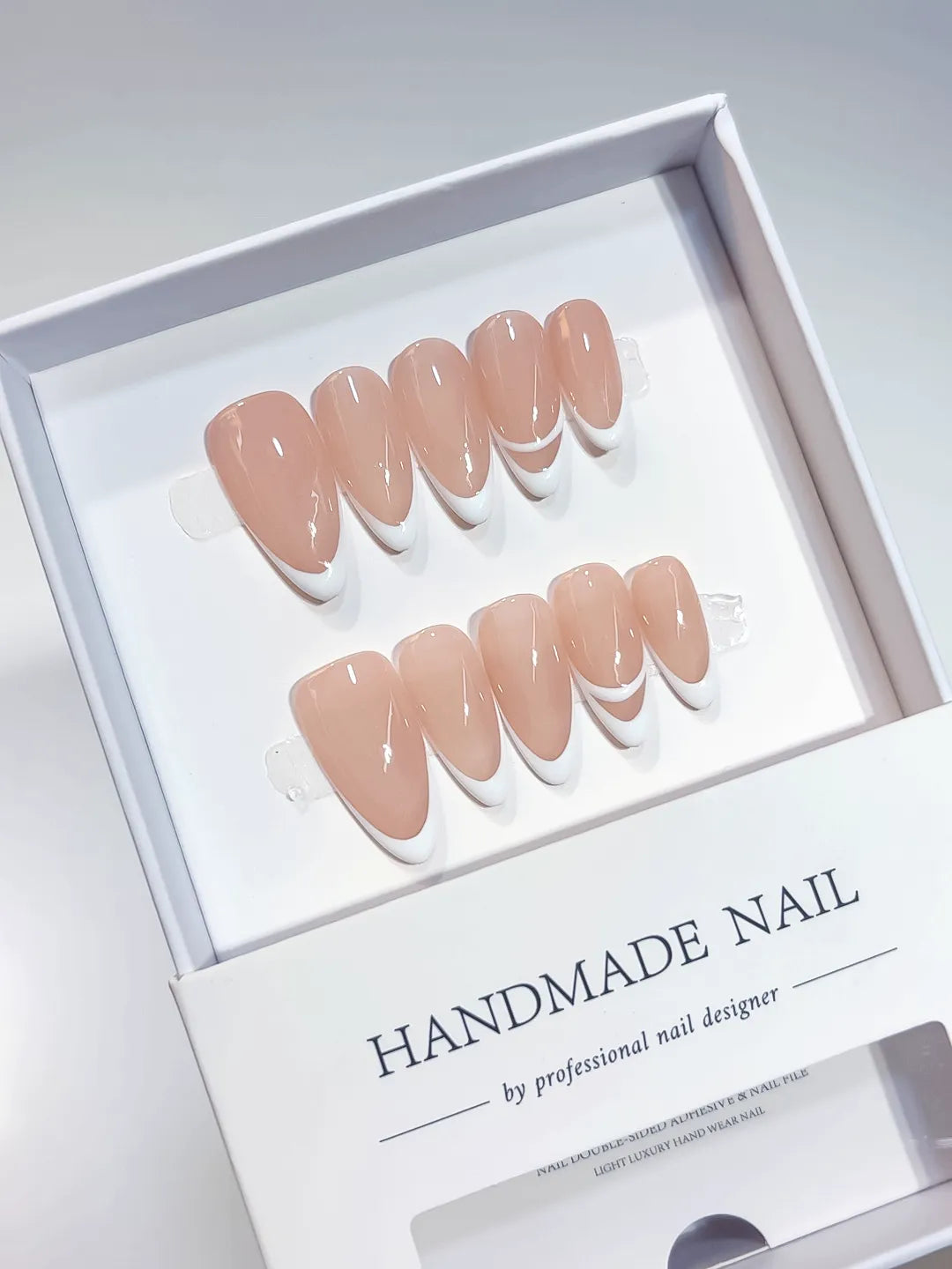 handmade press on nails in nude french design with double line accent, close-up view