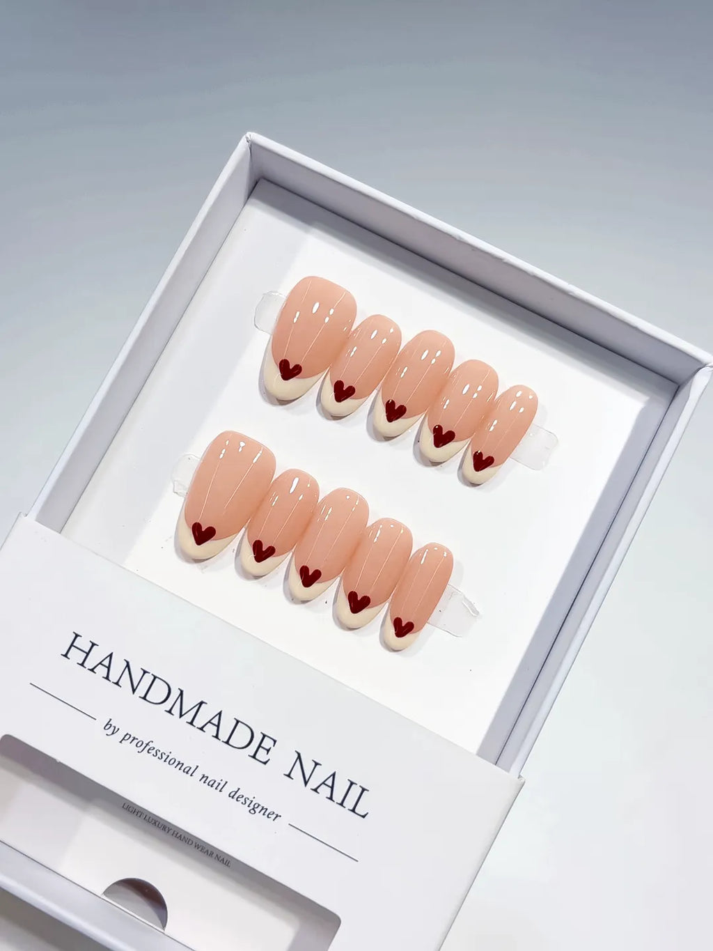 handmade press on nails set, close-up of medium oval nude base with white french and red hearts