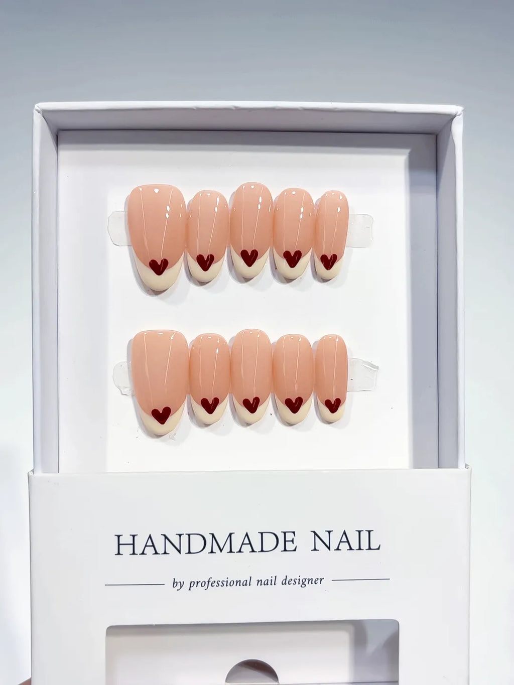 handmade press on nails set, close-up of medium oval nude base with white french and red hearts