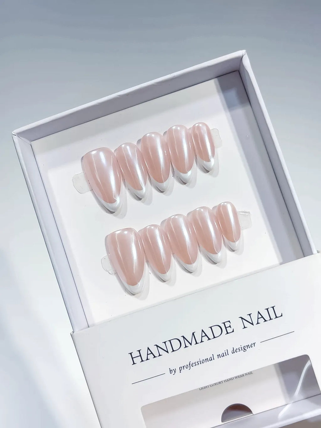 handmade press on nails, medium almond nude french with white tips, angled view
