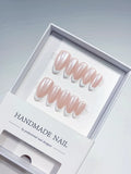 handmade press on nails, medium almond nude french with white tips, angled view