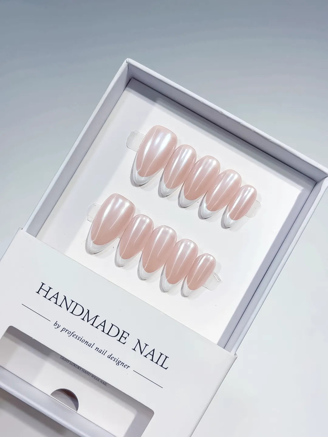 handmade press on nails, medium almond nude french with white tips, angled view
