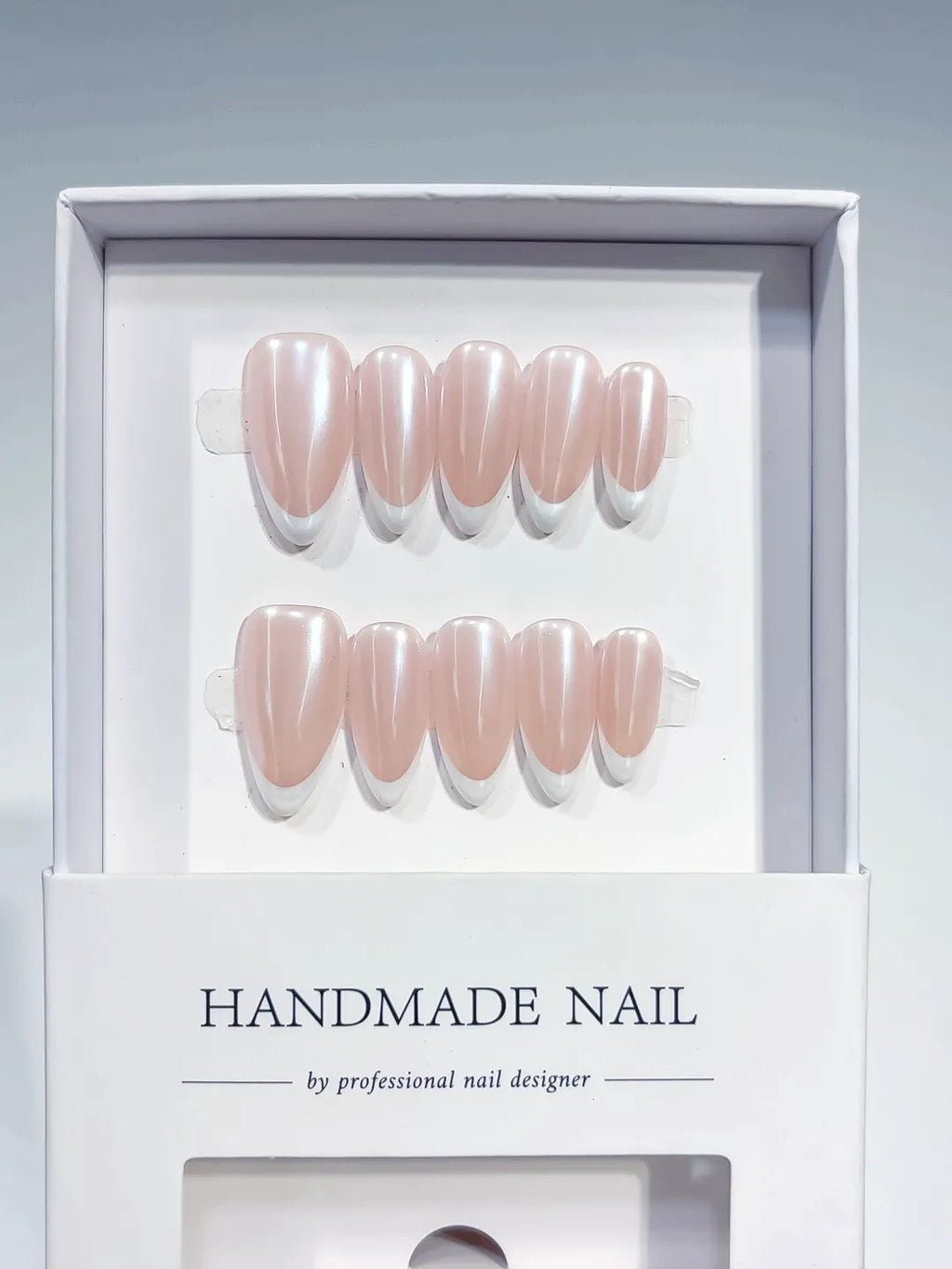 handmade press on nails, medium almond nude french with white tips, angled view