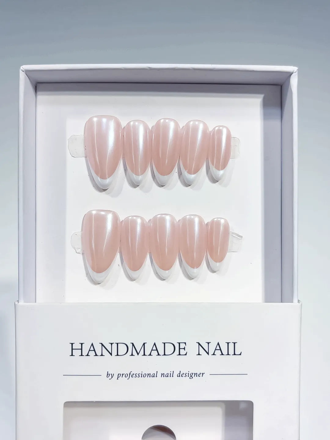 handmade press on nails, medium almond nude french with white tips, angled view