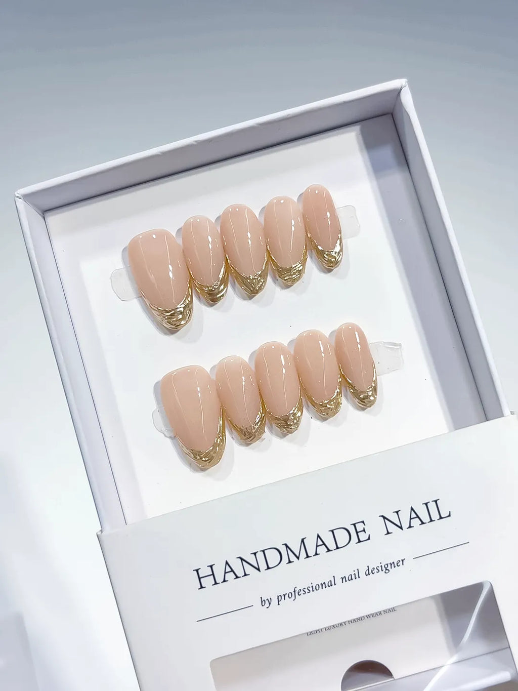 medium oval nude with gold french lines, handmade press on nails closeup