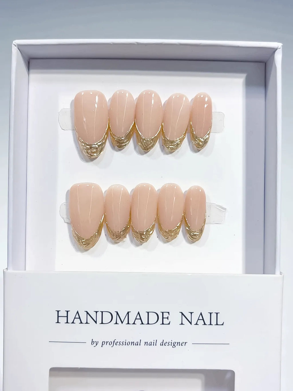 medium oval nude with gold french lines, handmade press on nails closeup