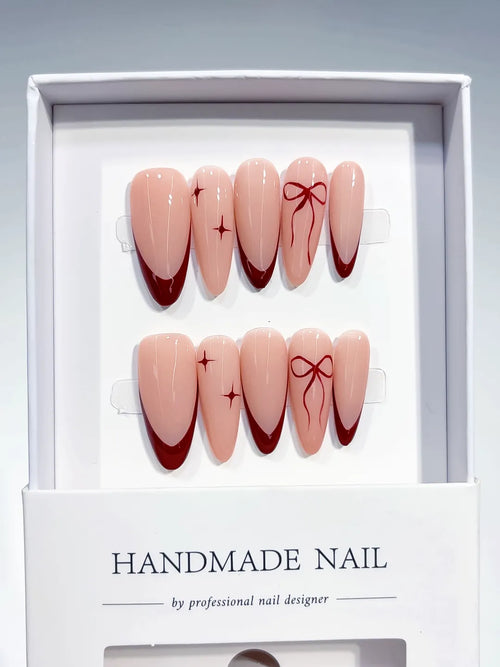 long almond nude base with red french tips and bow accents, handmade press on nails centerpiece