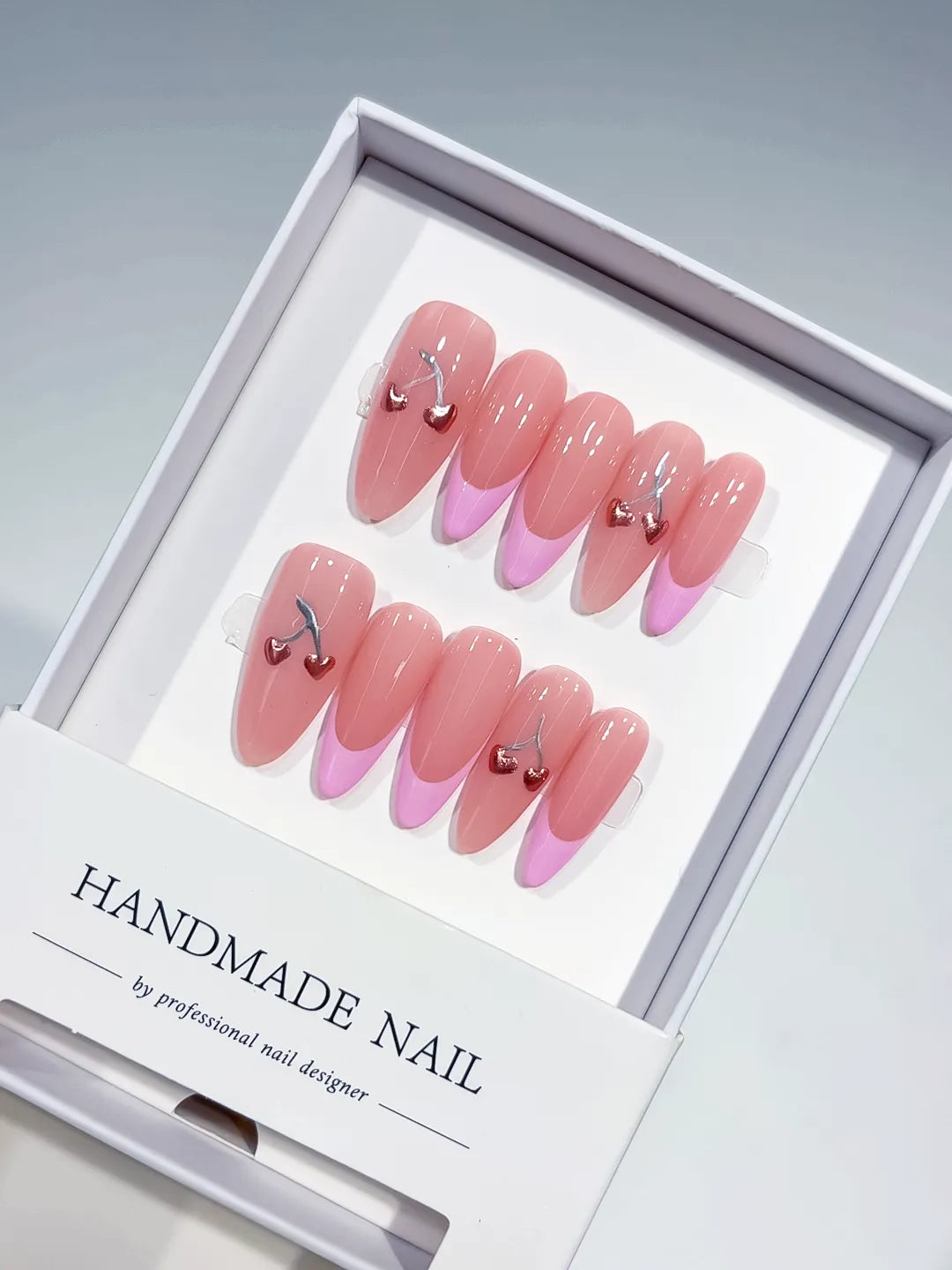 long almond pink french with cherry hearts, handmade press on nails closeup