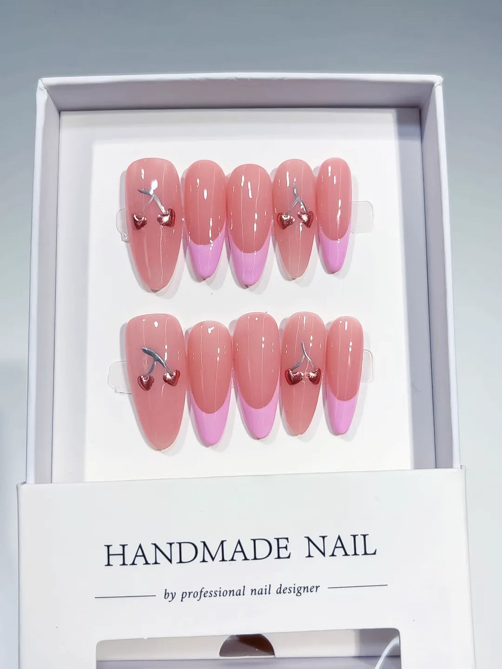 long almond pink french with cherry hearts, handmade press on nails closeup