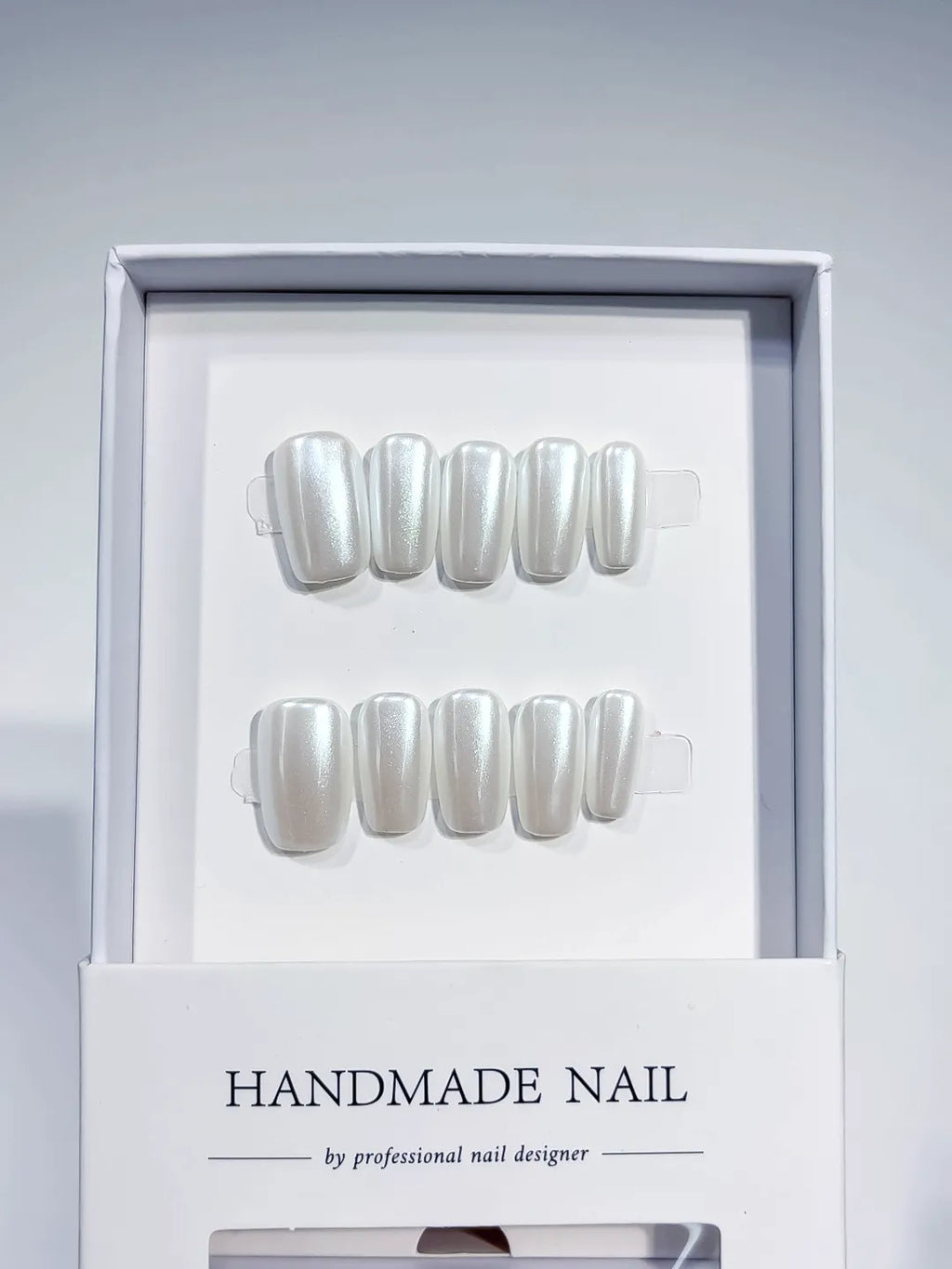 angled view of white glazed handmade press on nails with natural sheen