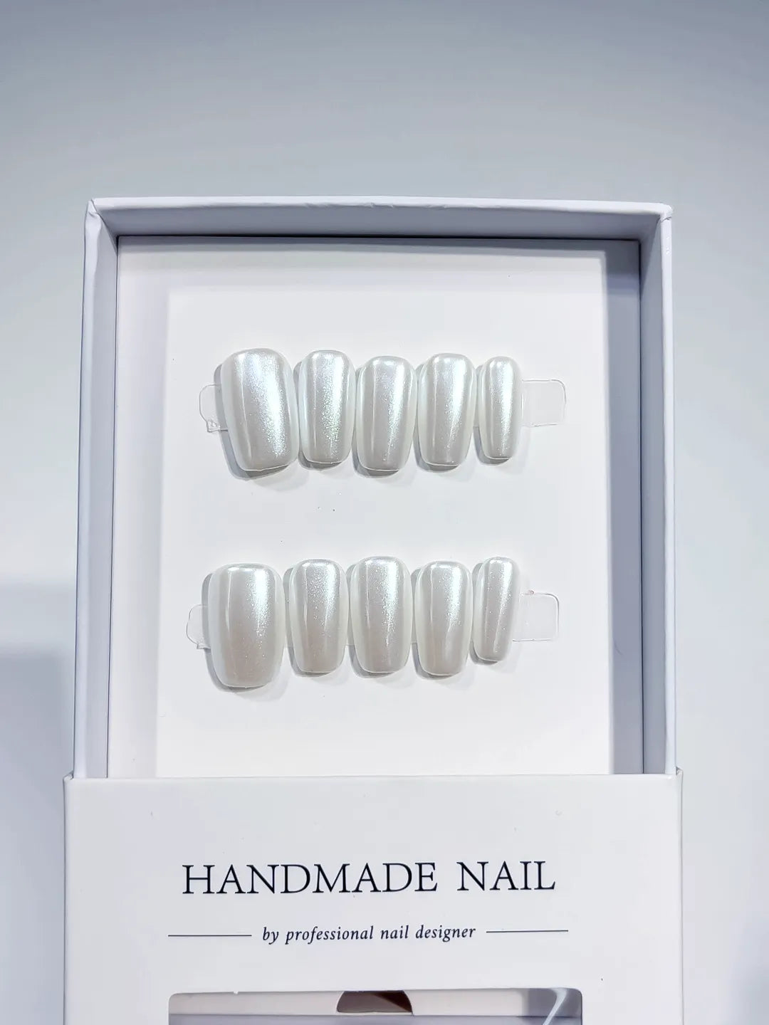 angled view of white glazed handmade press on nails with natural sheen