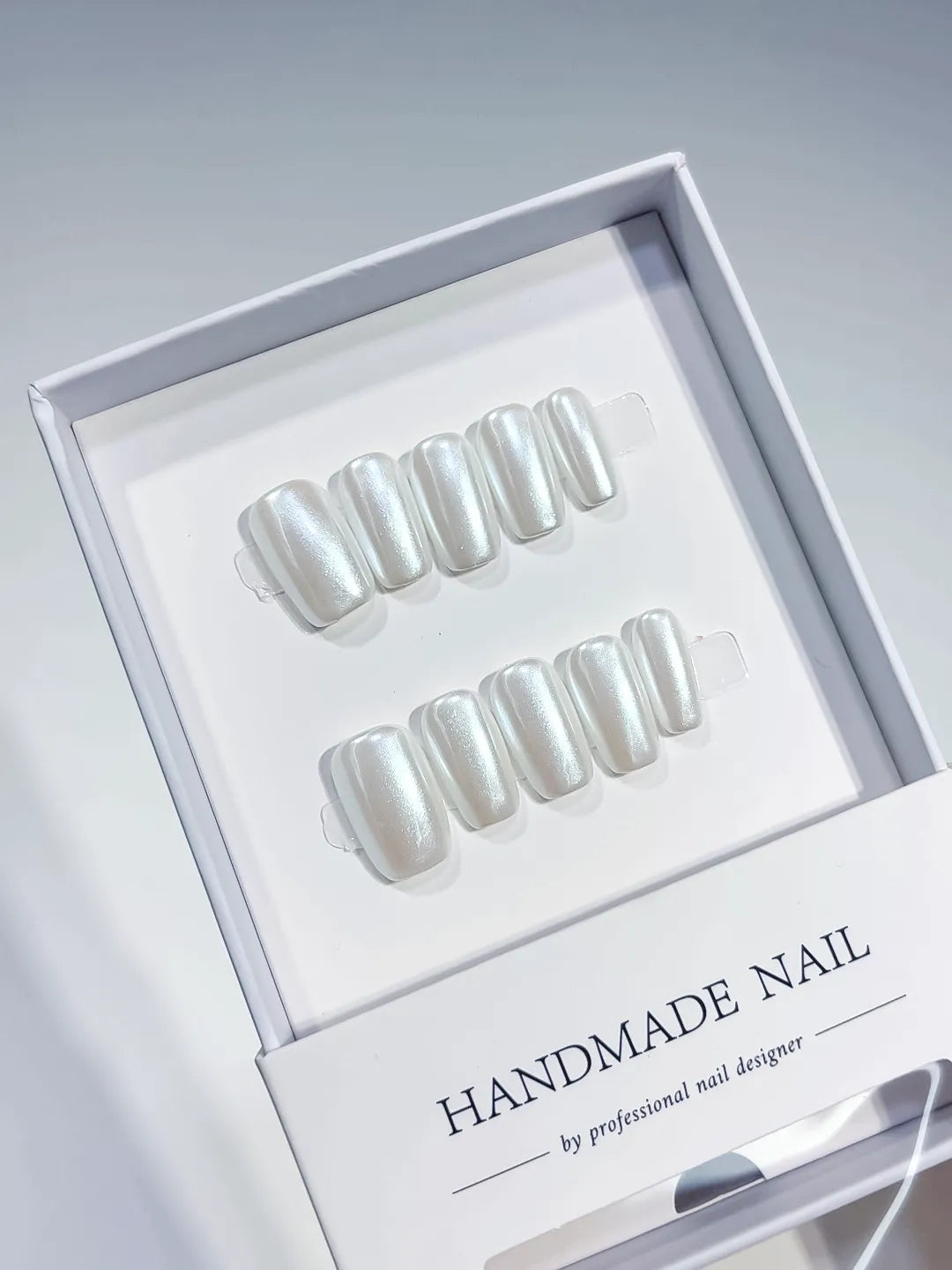 angled view of white glazed handmade press on nails with natural sheen