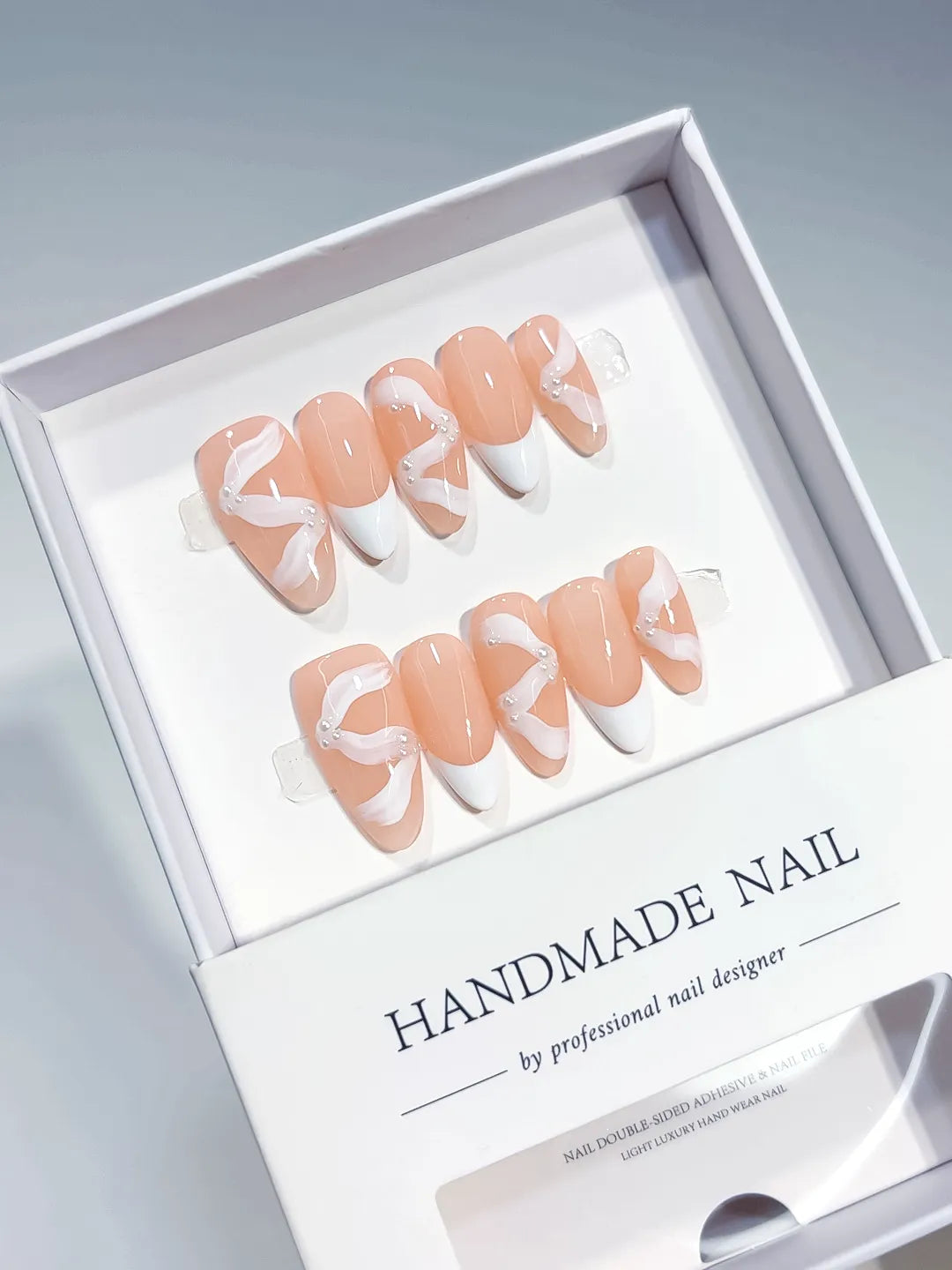 Nude White French tip Bow Swirl press on nails angled view