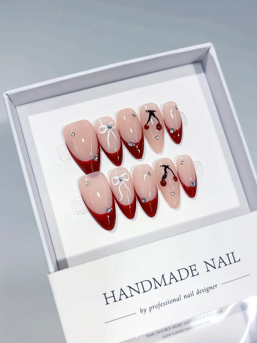 Nude Red French tip Bow Cherry Rhinestone press on nails angled view