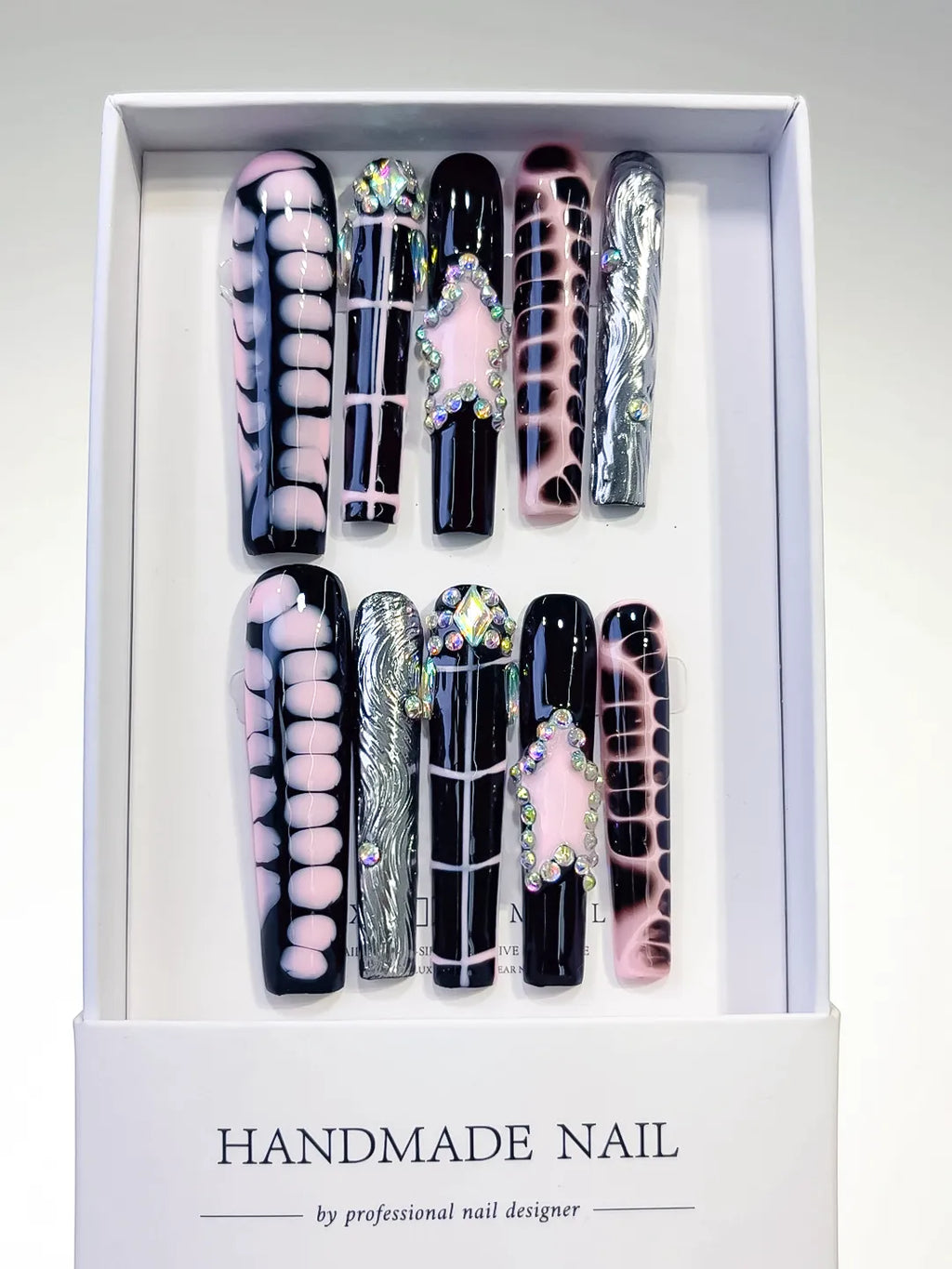 handmade press on nails set in long square black and pink with chrome accents and 3D rhinestone frame centerpiece