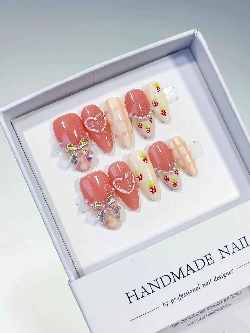 Pink White French tip Heart Bow Strawberry Grid Pattern press on nails angled view