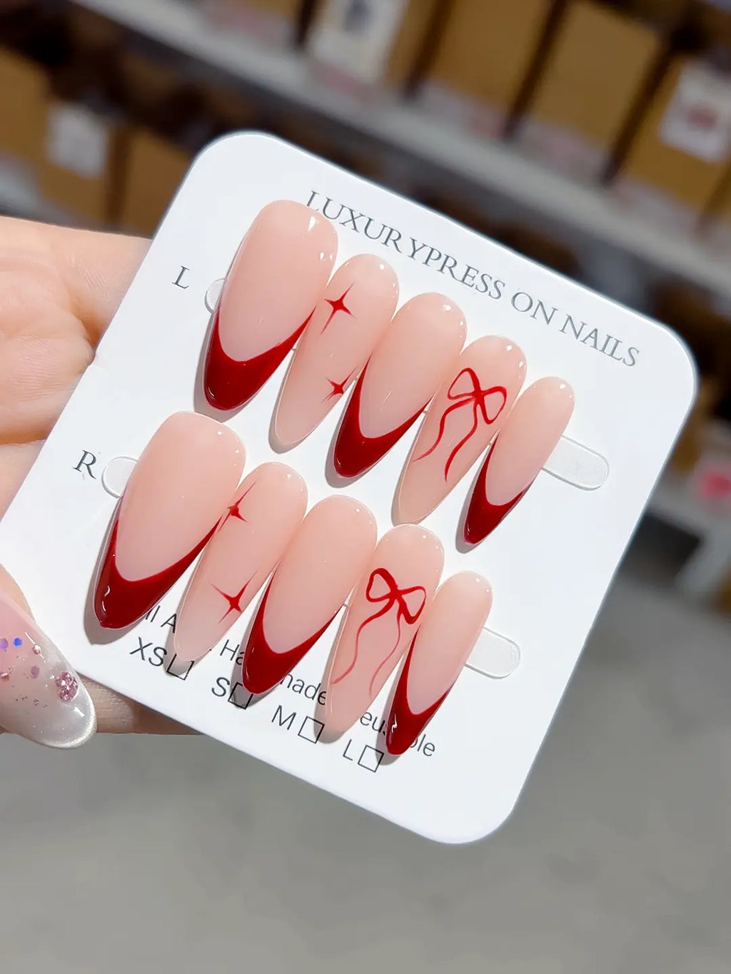 long almond nude base with red french tips and bow accents, handmade press on nails centerpiece
