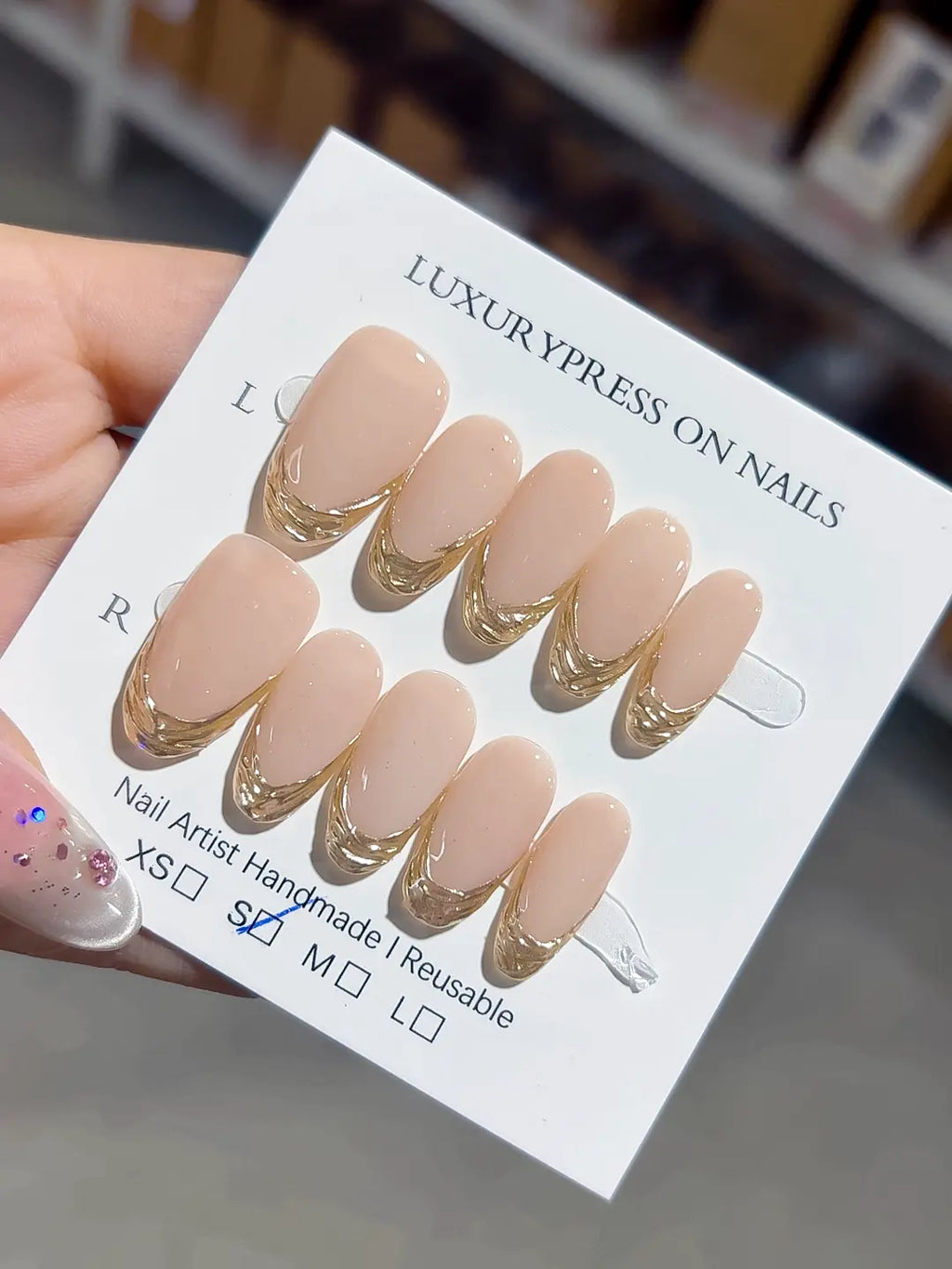 medium oval nude with gold french lines, handmade press on nails closeup